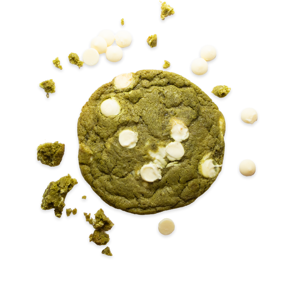 Matcha cookie surrounded by crumbs and white chocolate chunks