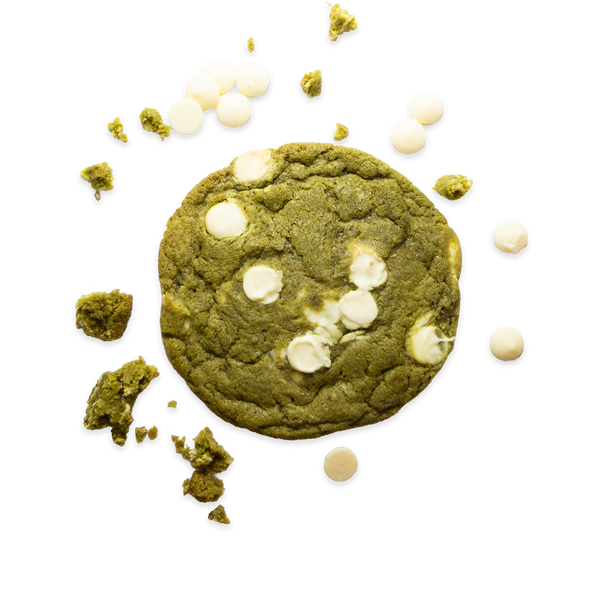 Matcha cookie surrounded by crumbs and white chocolate chunks